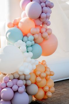 a bunch of balloons that are in the shape of hearts on a wooden floor next to a white couch