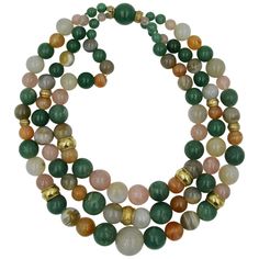 Three graduated strands of spectacular natural mined gemstones are linked together by 14 Karat Gold bands in this stunning Retro Modern Mid-Century bead necklace. The triple strand necklace features 43 Green Aventurine beads, 16 Rose Quartz beads, 14 Carnelian beads, 9 Agate beads, and 21 Gray Chalcedony beads. The largest bead is 20mm (.8 inches) in diameter. The combination of the natural gem colors with the warm 14 Karat gold braided beads is just magnificent! The necklace has been appraised Affordable Multi-strand Gold-tone Jewelry, Cheap Multi-strand Gold-tone Necklace, Watermelon Tourmaline Necklace, Gold Tassel Necklace, Red Tourmaline, Belt Vintage, Aquamarine Beads, Gold Bead Necklace, Gem Jewelry