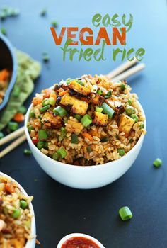 two bowls filled with rice and vegetables next to chopsticks on a blue surface