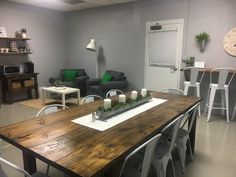 a living room filled with furniture and a wooden table topped with candles on top of it