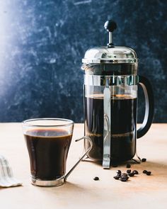 the french press coffee is next to a cup of coffee