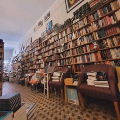 a room filled with lots of books next to a wall covered in shelves full of books