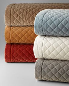 four blankets stacked on top of each other in different colors and sizes, with one blanket folded