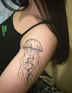 a woman's arm with a tattoo on it that has a drawing of a jellyfish