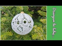 a crocheted ornament hanging from a pine tree with the words dream on it