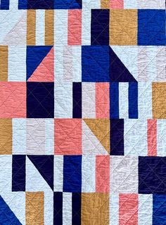 an abstract quilt made up of different colored blocks and lines, with one block in the middle