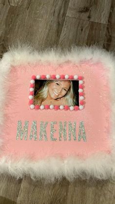 a pink and white photo frame with the words makenna on it in front of a wooden floor