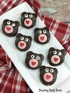 chocolate teddy bear cookies with pink icing on a white plate and red checkered tablecloth