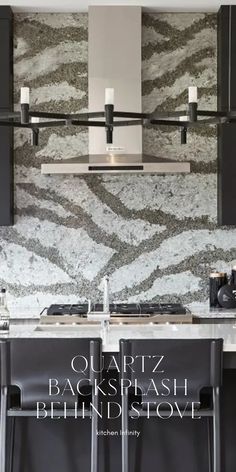 a kitchen with black cabinets and marble counter tops