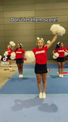 cheerleaders in red and black outfits are performing on a blue mat with the words don't let them score