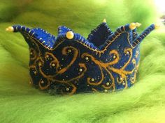 a blue and gold crown sitting on top of a green surface