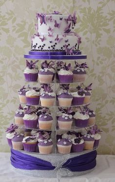 a wedding cake and cupcakes are stacked on top of each other in the shape of a tree