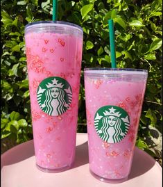 two starbucks cups with pink sprinkles on them