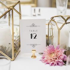 the table numbers are placed on top of each other near some candles and flowers in vases