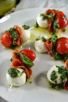 small appetizers with tomatoes, mozzarella and parsley on a white plate