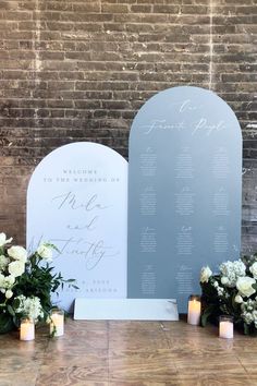 wedding ceremony setup with white flowers and greenery in front of a stone arch sign