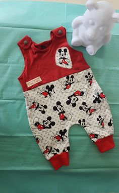 a red and white mickey mouse romper next to a tissue paper dispenser