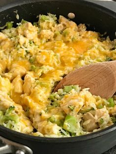 a wooden spoon is in a skillet filled with broccoli and chicken casserole