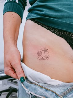 a woman's stomach with a small tattoo on it