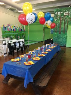 a blue table topped with lots of balloons