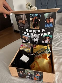 someone is opening up a box with pictures and other things in it on the bed