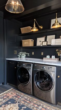 a washer and dryer in a room with dark blue walls, gold accents