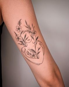 a woman's arm with flowers and a vase tattoo on the left side of her body