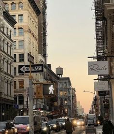 a city street filled with lots of traffic and tall buildings next to eachother