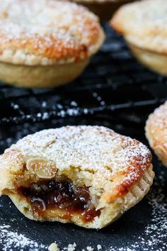 several pastries on a cooling rack with powdered sugar and jelly in the middle