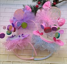 two pink and blue hats with bows on them sitting next to each other near a christmas tree