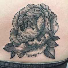 a black and white rose tattoo on the back of a woman's upper arm