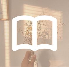 a person holding up an open book with flowers in front of them and the text reading books above it