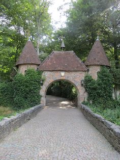 an old stone gate with two towers on each side and a walkway leading to it