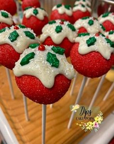 strawberry cake pops with white icing and green leaves on them are ready to be eaten