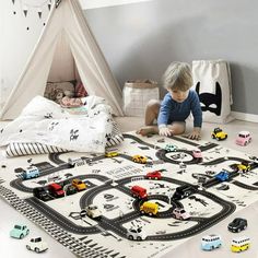 a young boy playing with toy cars on the floor in his playroom at home