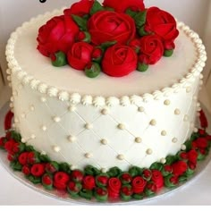 a white cake with red roses on top and the words deby cake written below