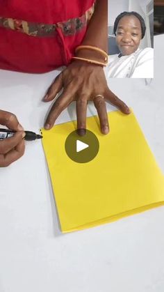 a person cutting up a yellow piece of paper