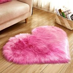 a pink heart shaped rug sitting on top of a wooden floor