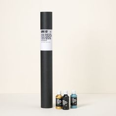 three different types of paint next to each other on a white surface with a black tube