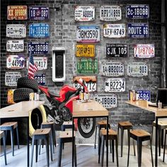 a motorcycle parked in front of a brick wall with license plates on it's walls