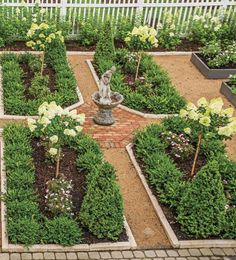 a garden with many different types of plants and flowers in it, including an angel statue