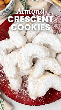 almond crescent cookies on a red plate with powdered sugar