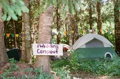 there is a sign that says wedding camp out in the woods next to some tents