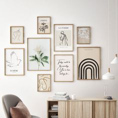 a white room with many framed pictures on the wall and a chair in front of it