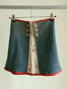 a skirt hanging on a clothes line with two buttons and one button at the bottom