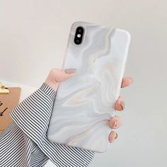 a woman is holding up her phone case