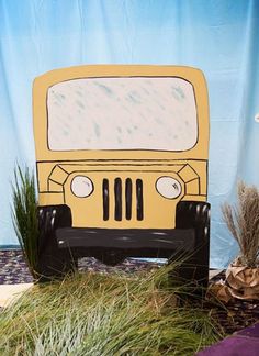 a paper cut out of a school bus sitting on top of a grass covered field