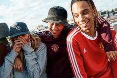 three people sitting next to each other on a bench