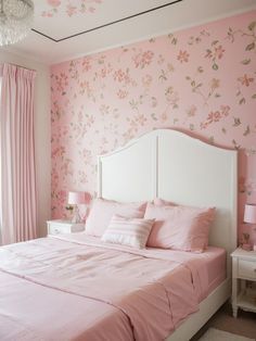 a bedroom decorated in pink and white with flowers on the walls, bedding, nightstands and curtains