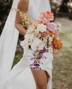 a woman in white dress holding a bouquet of flowers